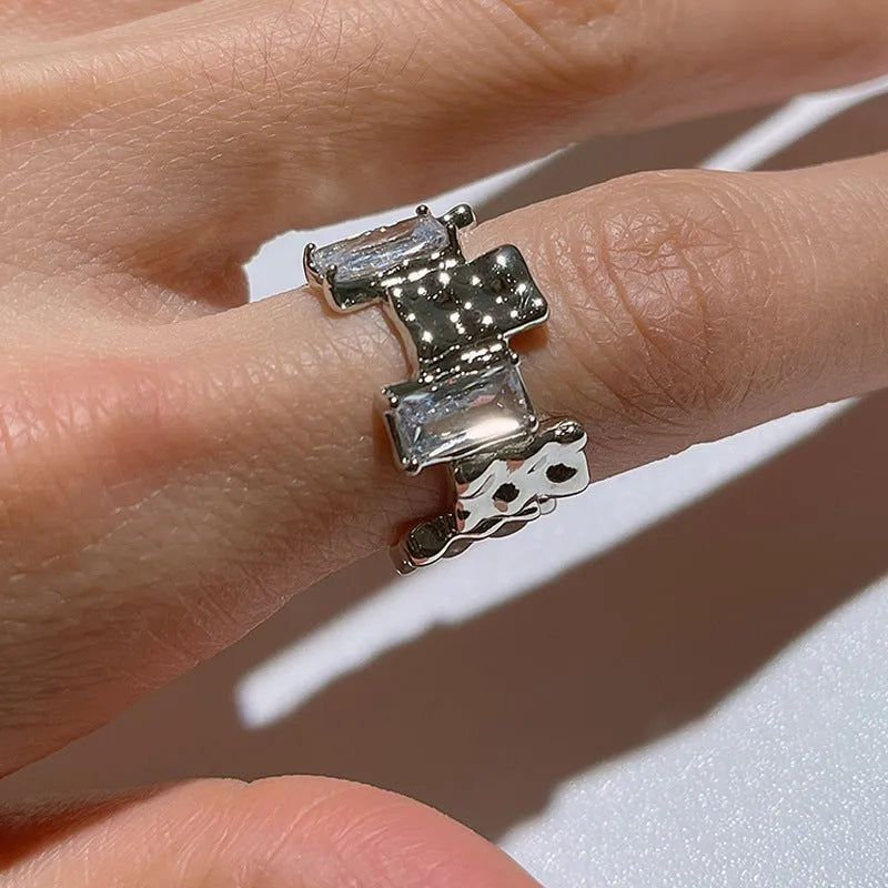 Silver geometric cross ring with open gemstone setting and retro national fashion decorative elements.