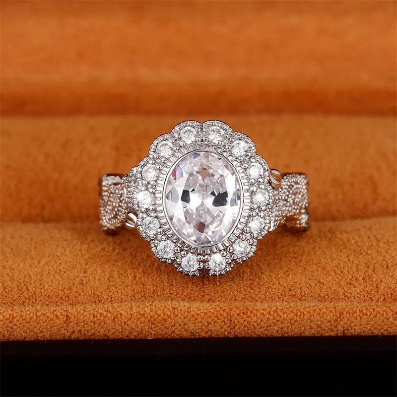 A geometric copper ring for women with a white gold coloured plating and a round zircon stone, shown on a finger.