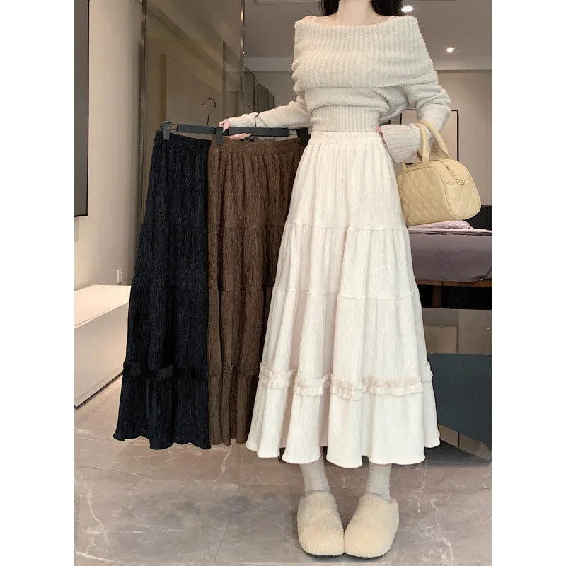 Women's milky white corduroy A-line midi skirt with an elastic waistband, laid flat.