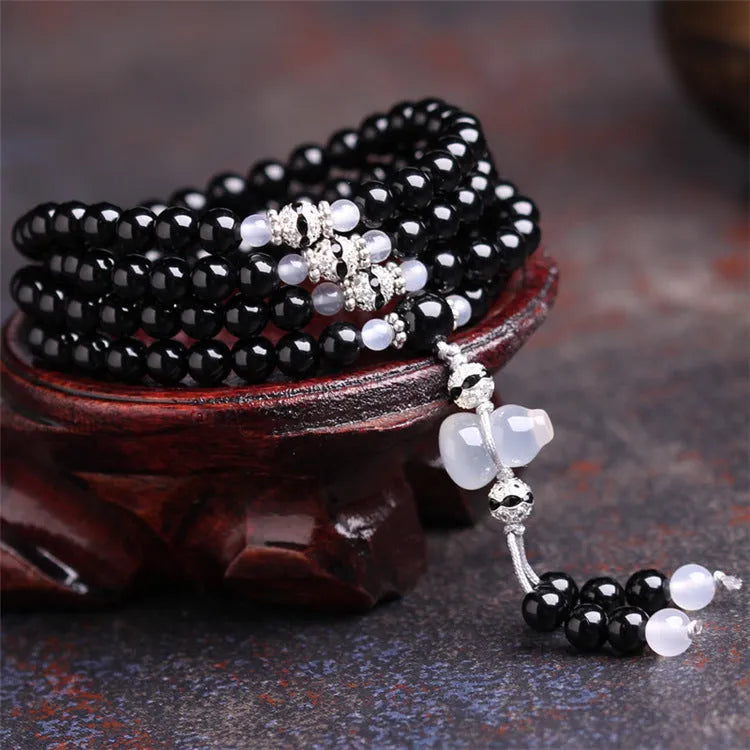 Natural black agate 108 bead bracelet with 8mm geometric beads on a wrist.