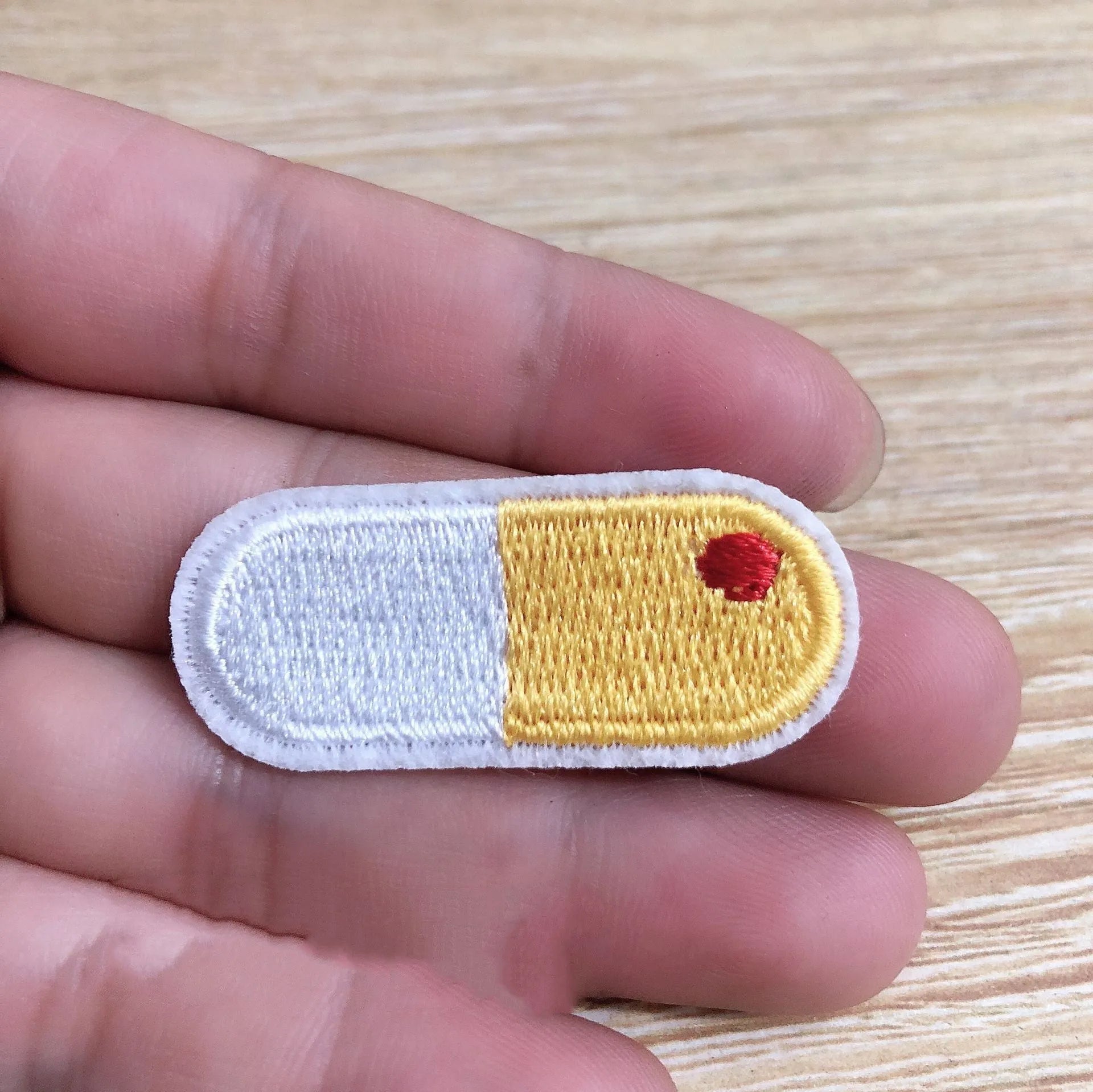 Ten embroidered cloth patch badges with textured threadwork for iron-on or sew-on clothing decoration.