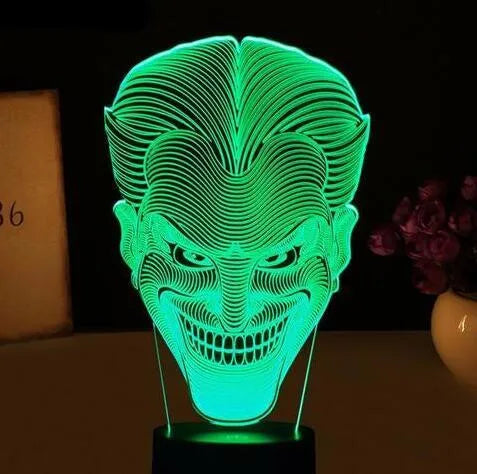 A 3D acrylic LED table lamp displaying colourful light patterns, with a remote control and USB cable.