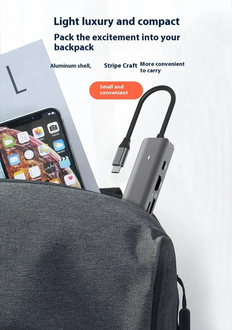Silver aluminium 7-in-1 USB-C hub with SD card slot, microSD slot, USB-A, and USB-C ports.