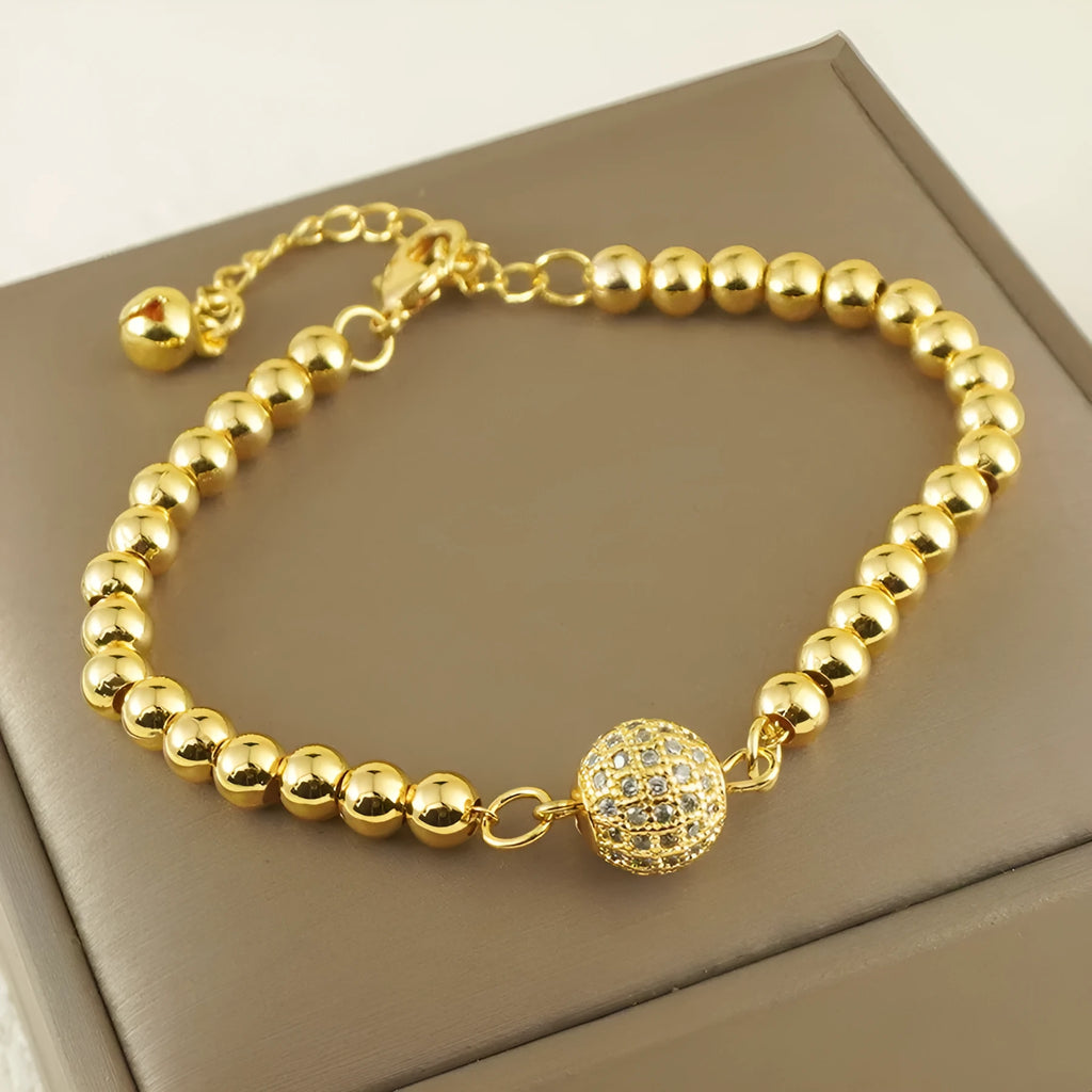 Close-up of a women's copper bracelet with a heart-shaped charm holding a round zircon stone, Arabic style design.