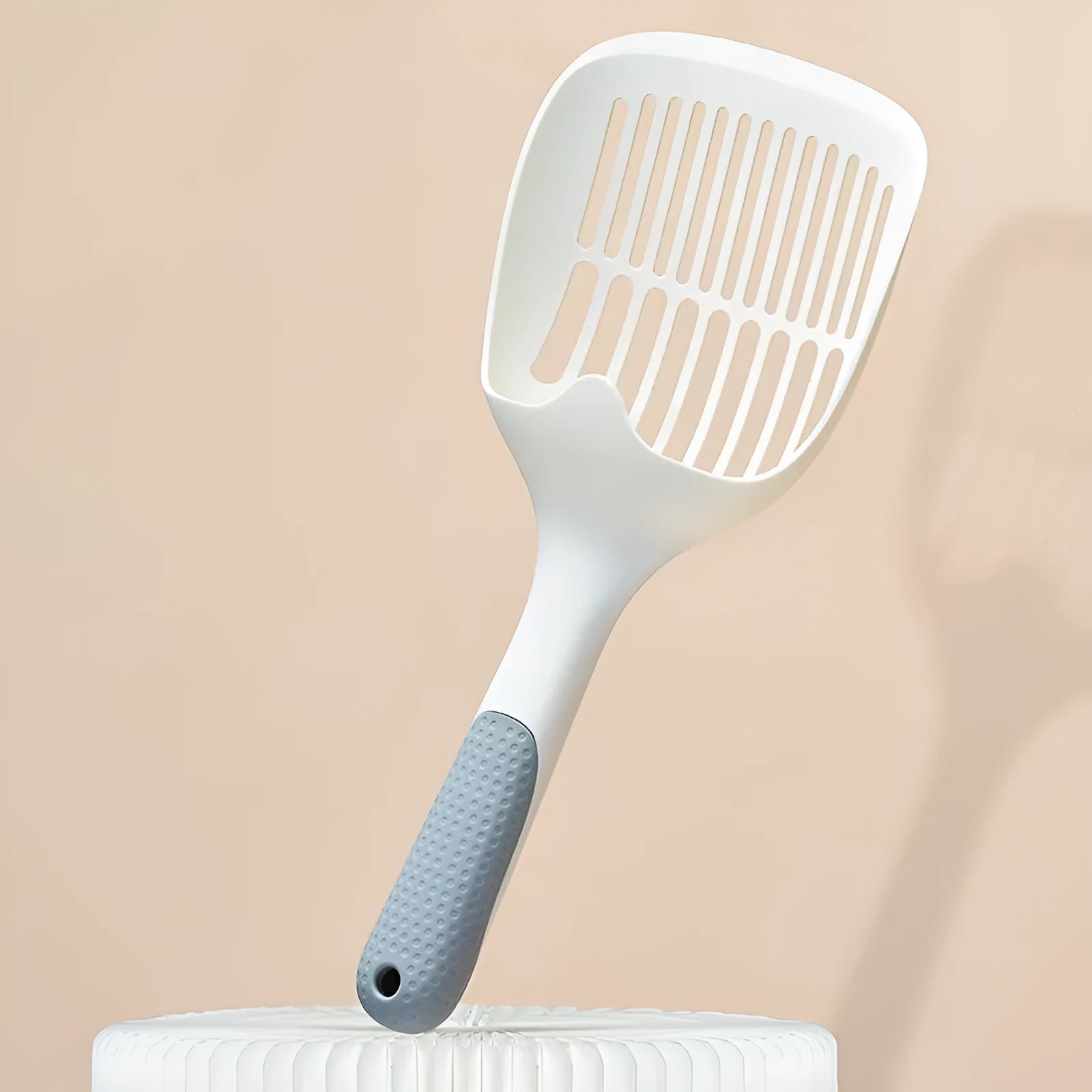 White plastic cat litter scoop with storage base for litter tray cleaning