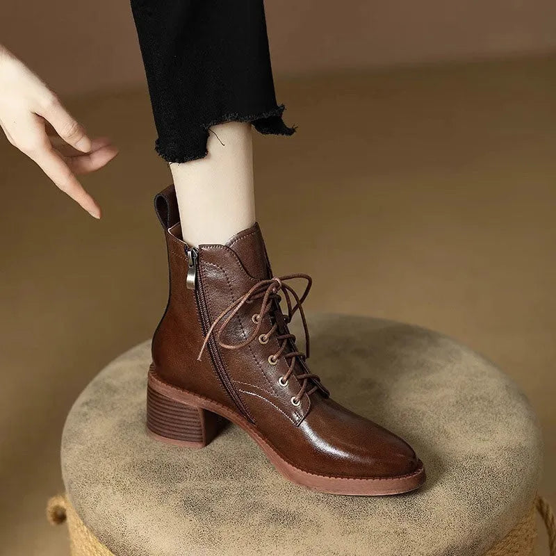 Women's black pointed-toe short tube boots with 5.5cm block heel on wooden floor