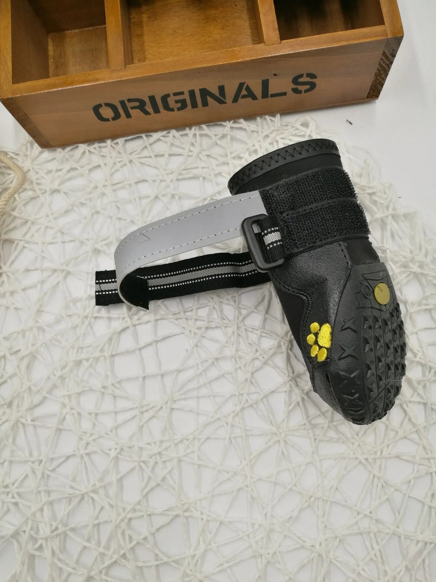 Black dog shoes with waterproof PVC sole and adjustable fuzzy belt on a white background