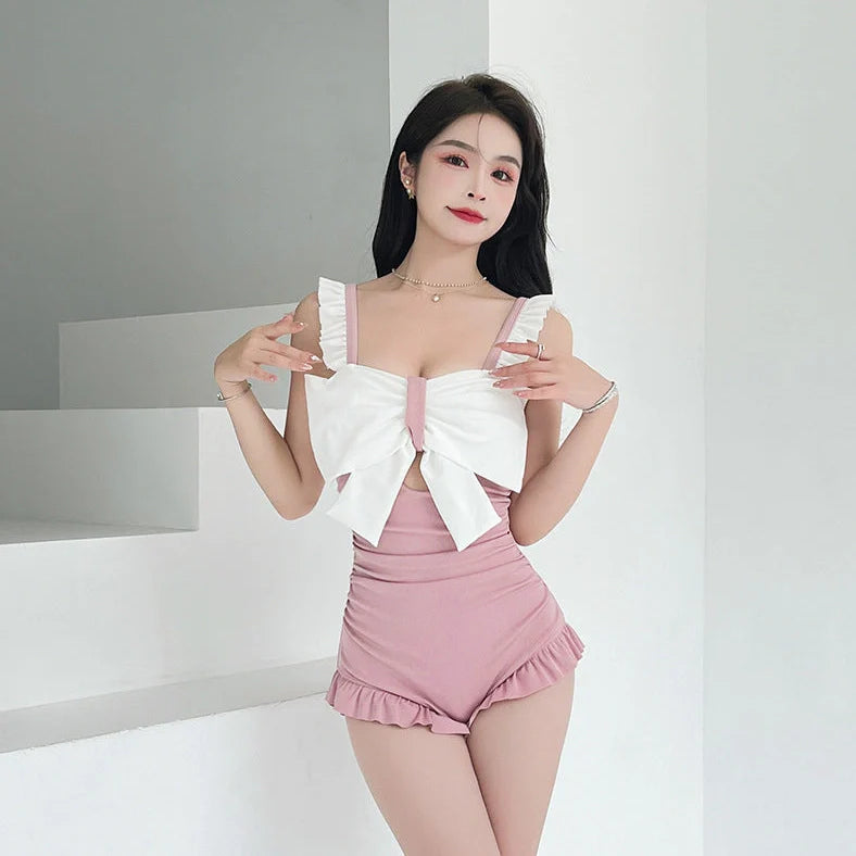 Women's one-piece swimsuit with adjustable bow detailing in solid colour