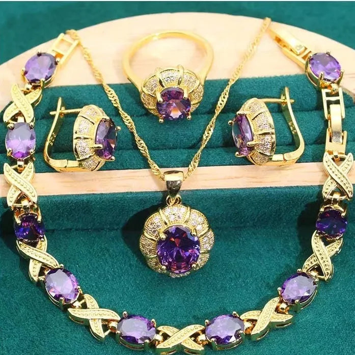 Gold plated jewellery set with coloured cubic zirconia stones showing necklace, earrings, ring, and bracelet.