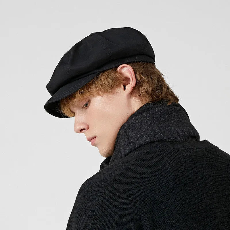 Cotton newsboy cap in black, octagonal dome crown, side view showing structure