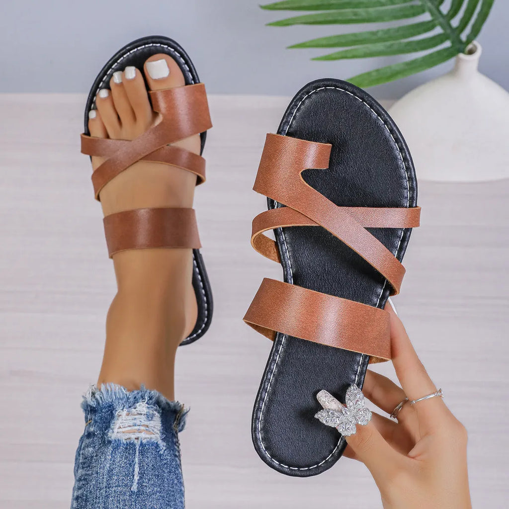 Pair of solid colour beach slippers with round toe and hollow-out pattern on the upper.