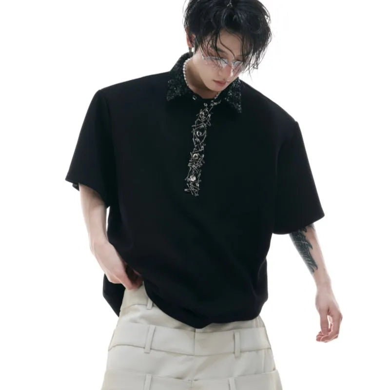 Men's black loose-fit short-sleeve polo shirt with heavy embroidery and sequin detailing on the square collar.