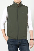 A man wearing a thin khaki coloured waistcoat vest with side seam pockets, shown in a casual setting.