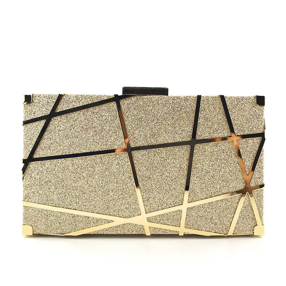 Gold glitter evening clutch bag with metal chain and lock closure on a table