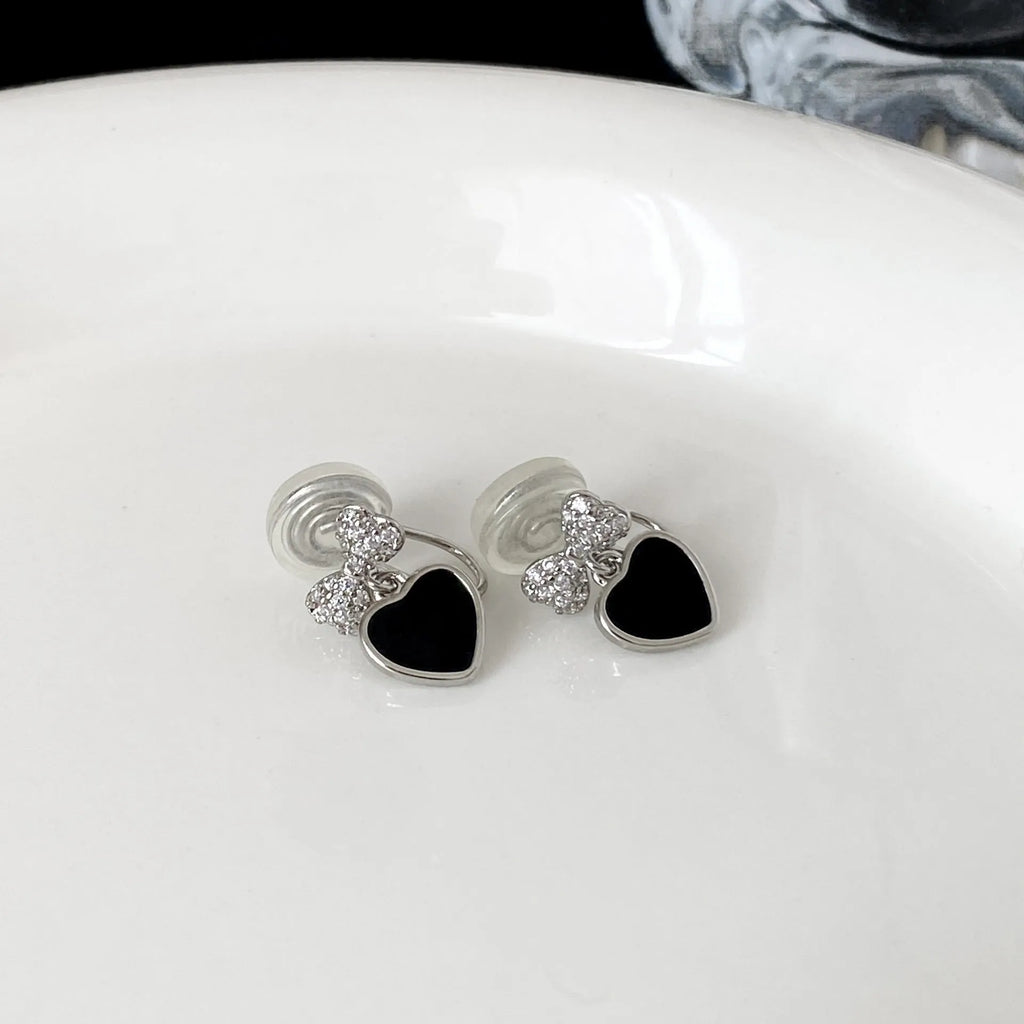 Copper earrings with inlaid zircon heart and bow shapes as a pair of ear clips or ear studs