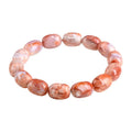 Natural cherry agate barrel bead bracelet with Ruyi charm on a white background.