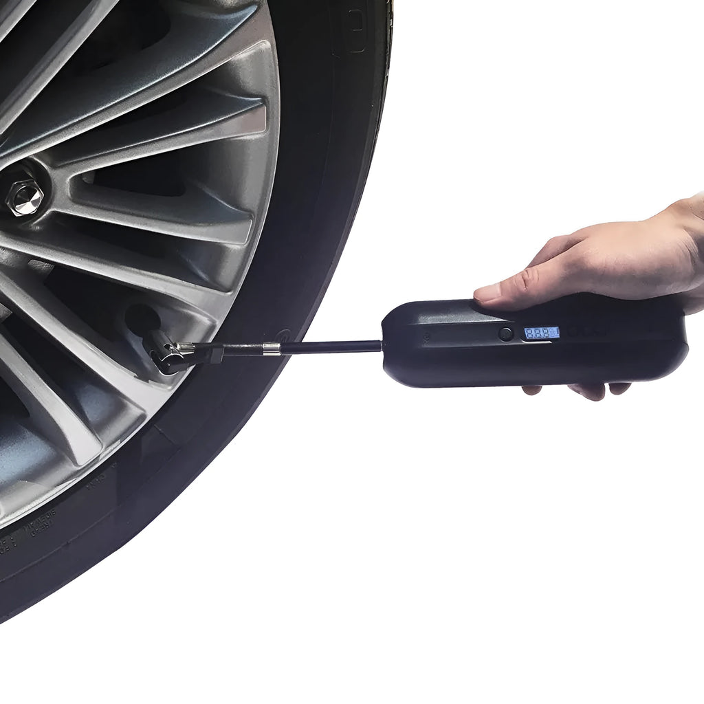 White portable electric tyre inflator with accessories on a non-slip mat, showing compact size and USB cable