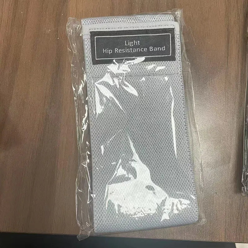 Cloth-covered nylon resistance band in light gray on a gym floor