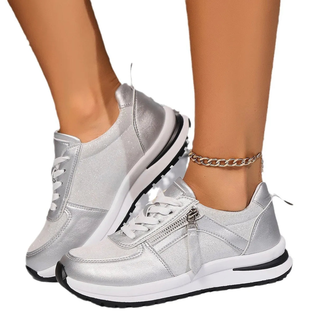 Gold women's flat lace-up pumps with round toe and shallow cut on a white background.