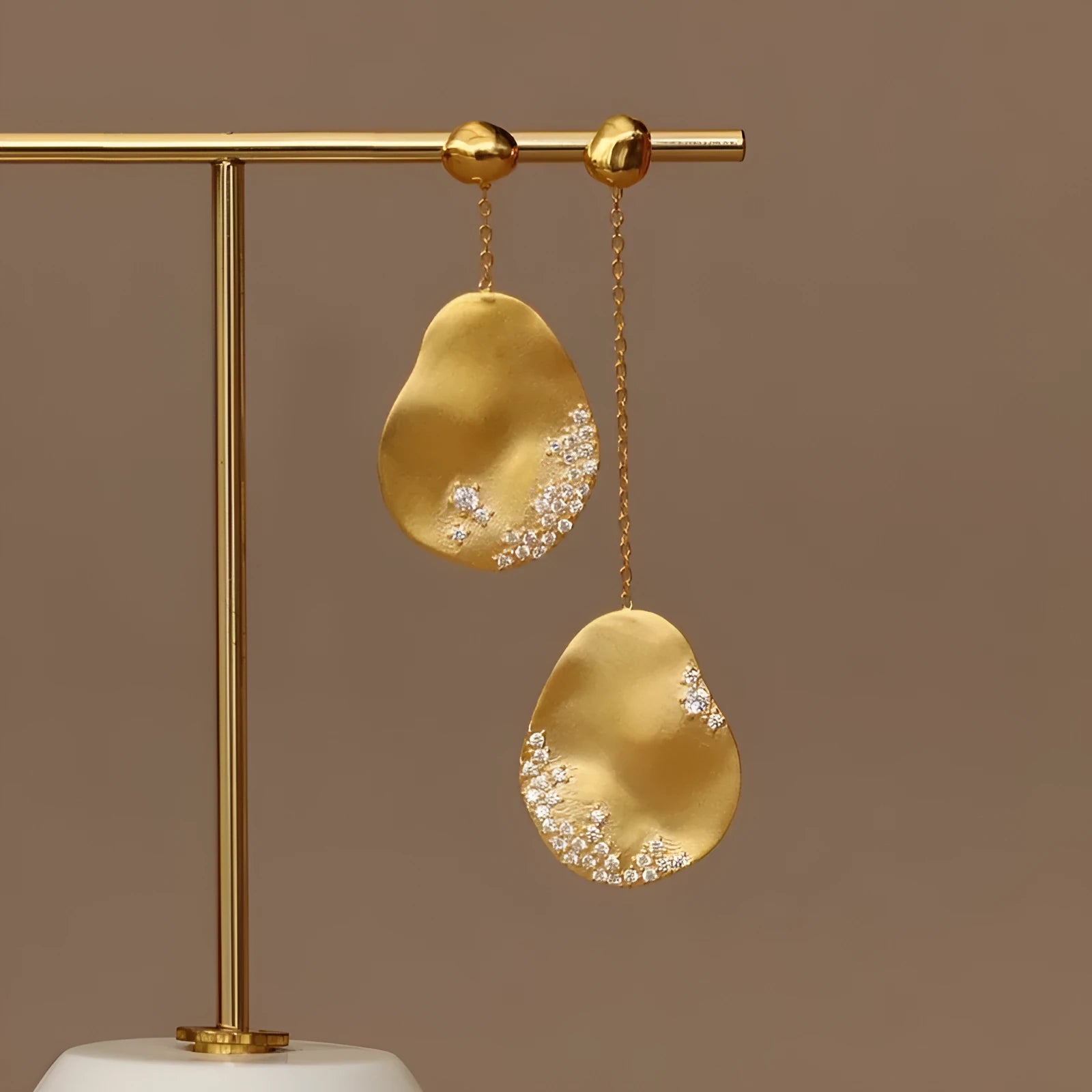 Asymmetric floral earrings with zircon mosaic detail in gold or silver colour