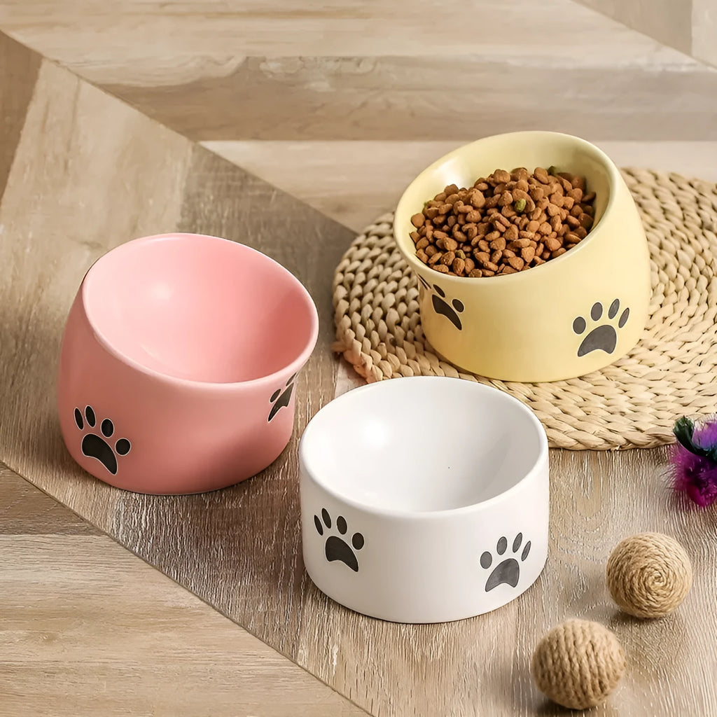 Ceramic cat bowl with slanted mouth design showing cat's paw pattern in yellow colour
