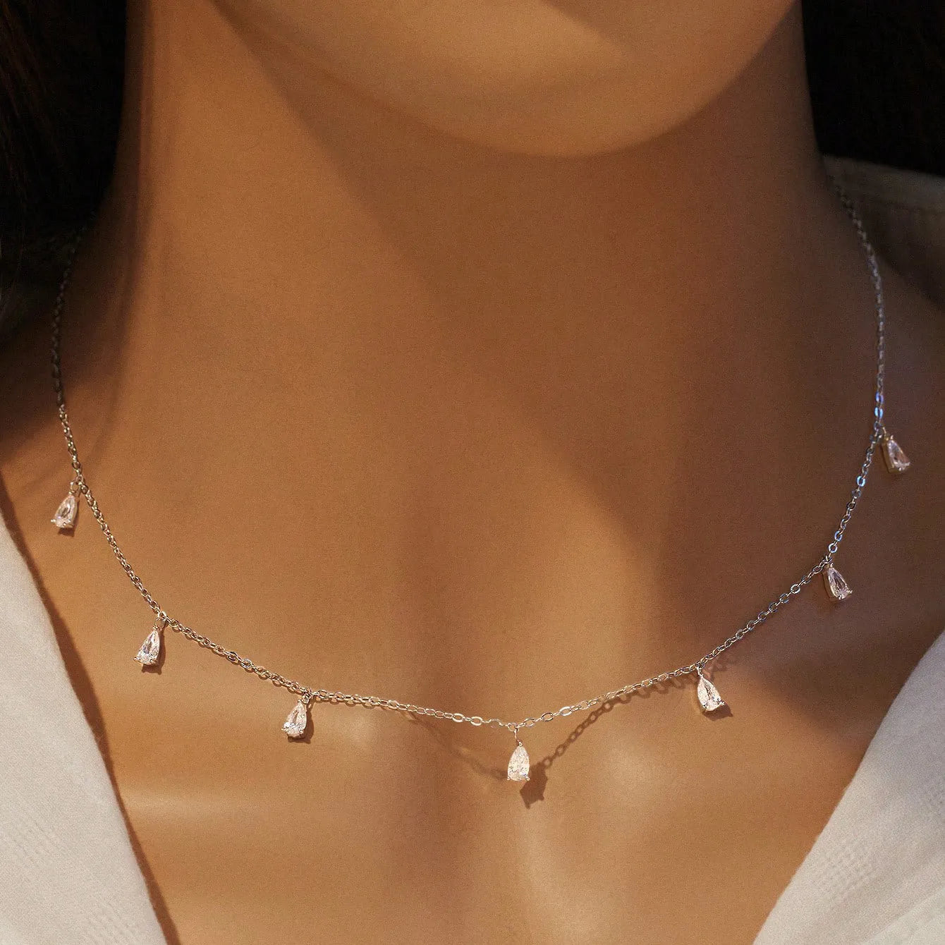 Women's silver necklace with drop-shaped zircon pendant on an adjustable O-chain, shown in silver finish.