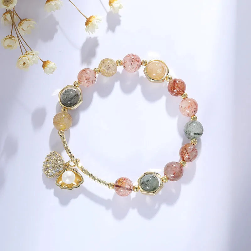 A women's crystal bracelet with colourful hair crystal shells and a red sealant flower shell on an electroplated band.