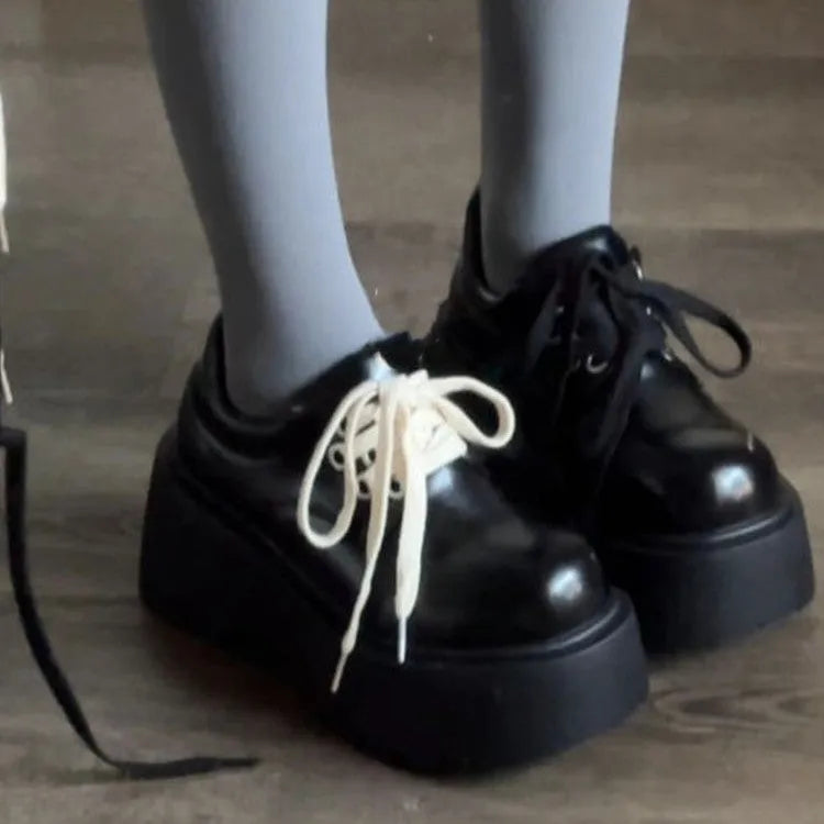 Matte black women's lace-up platform shoes with thick rubber sole and retro block heel.