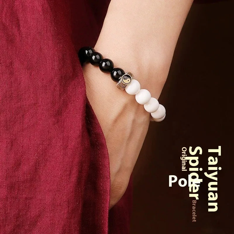 Black and white obsidian Taiji mantra bracelet with geometric beads and yin-yang symbol.