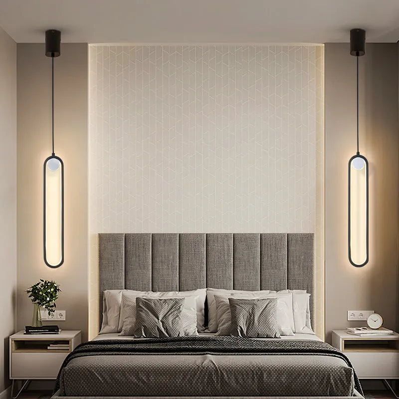 Nordic minimalist oval bedside chandelier with LED colour-changing light in Black A finish over a wooden side table