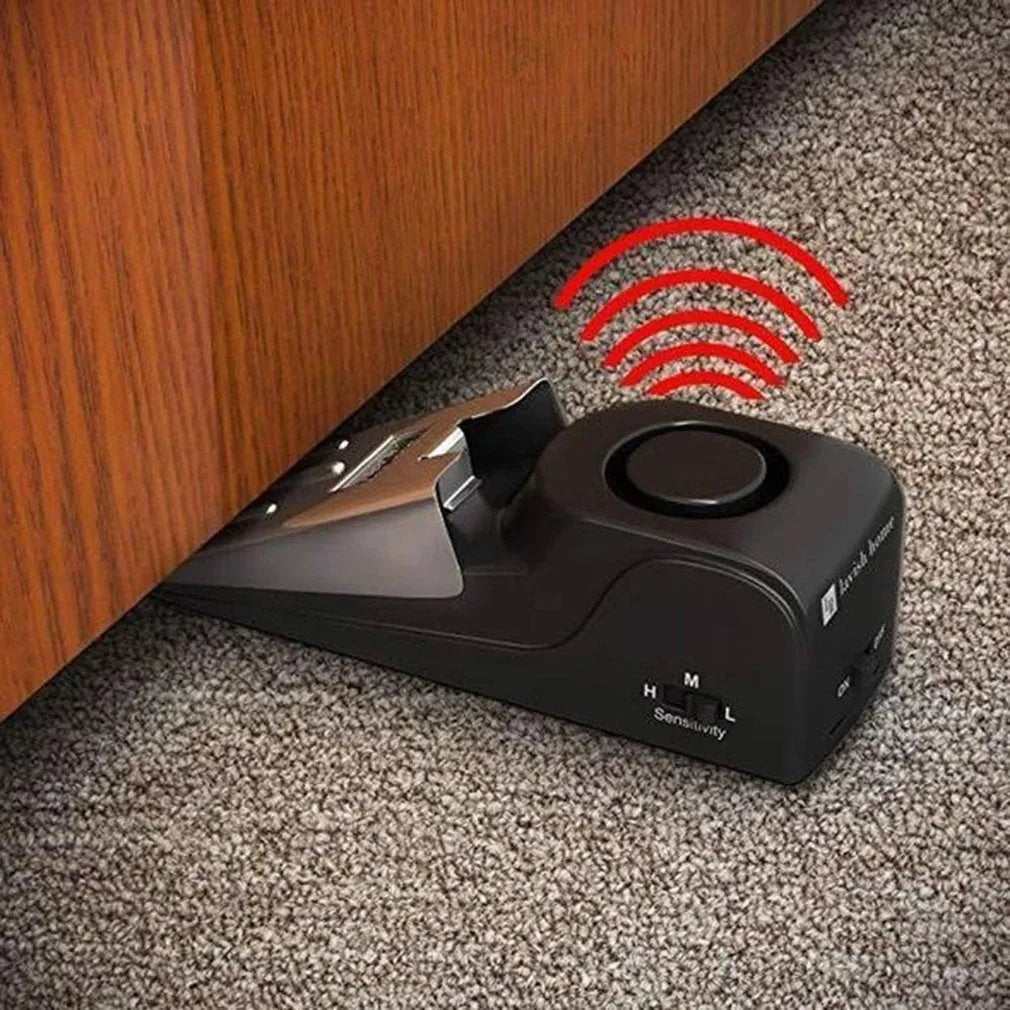 Black wedge-shaped door alarm with stainless steel cover and sensitivity controls