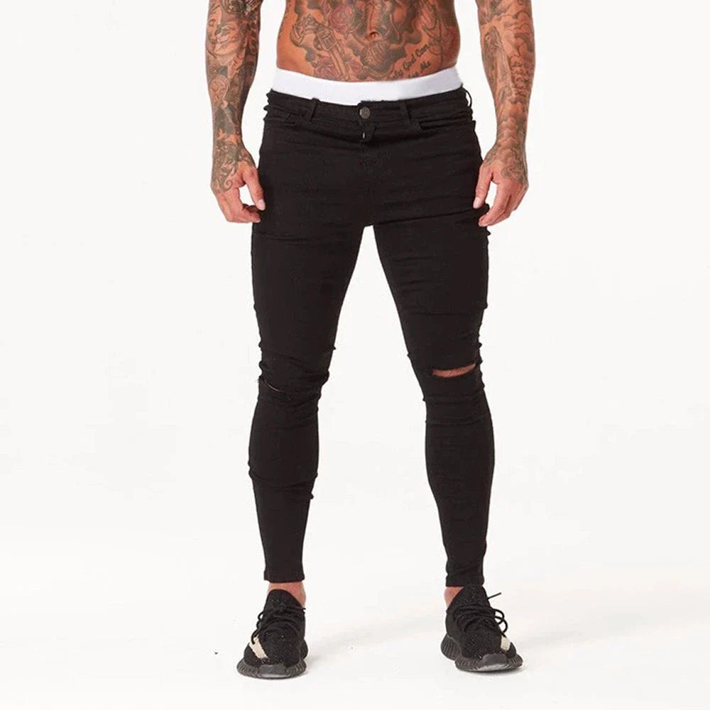 Premium distressed men's slim-fit jeans in black, featuring a stretchy mid-rise design and edgy, on-trend detailing