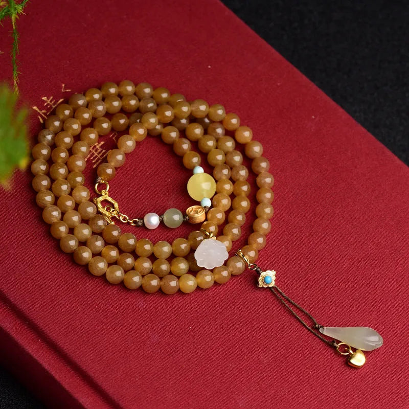 Green jade bead bracelet with leaf shapes and sequins on wrist