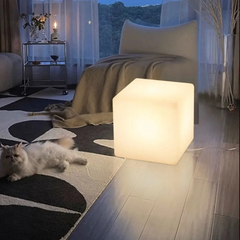 A modern white LED cube light stool sitting outdoors on a patio.