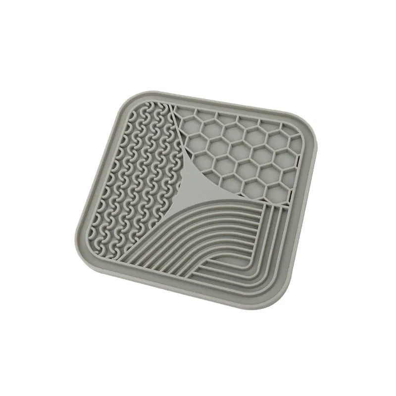 Gray silicone anti-choke slow feeding dog licking pad with textured surface on a flat surface