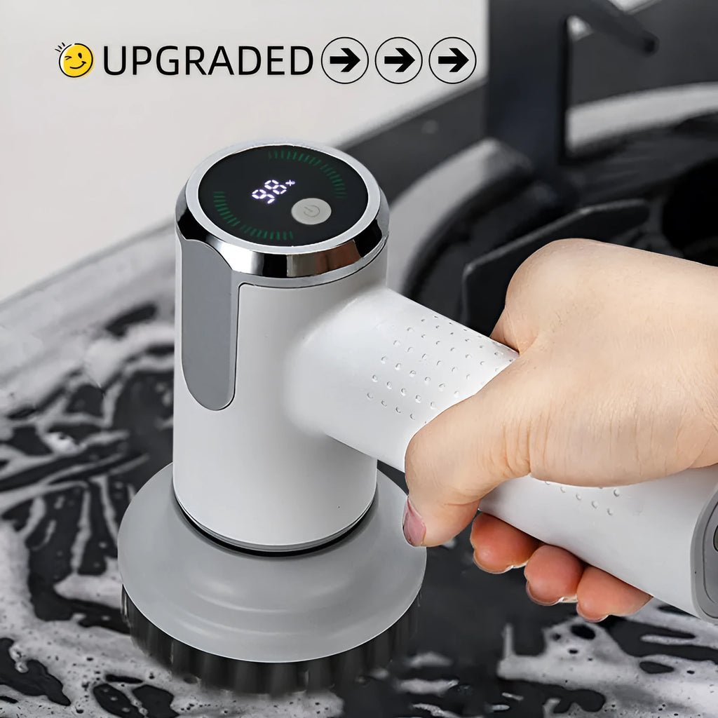 White cordless electric cleaning brush with interchangeable brush heads on a kitchen counter.