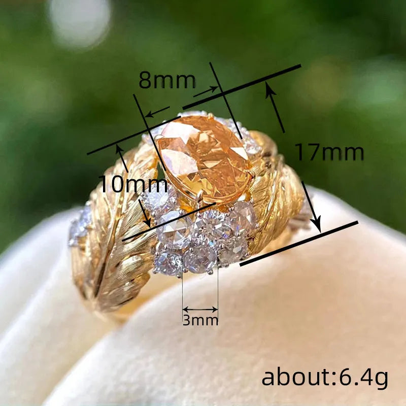 Gold women's ring with embossed feather design and yellow zircon stones on geometric shape