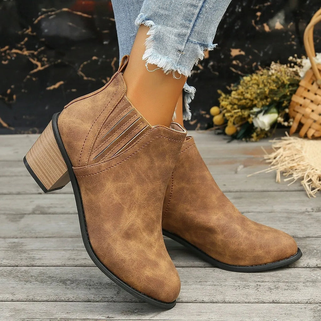 Black women's ankle boots with a pointed toe and thick square heel on a rubber sole.
