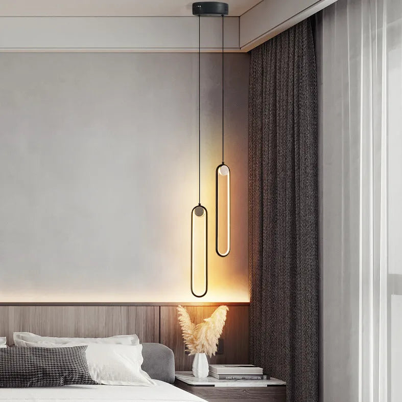 Nordic minimalist oval bedside chandelier with LED colour-changing light in Black A finish over a wooden side table