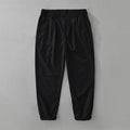 Man wearing loose straight-leg cotton linen trousers in a solid earthy colour.