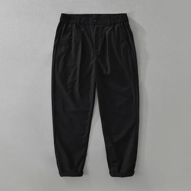 Man wearing loose straight-leg cotton linen trousers in a solid earthy colour.