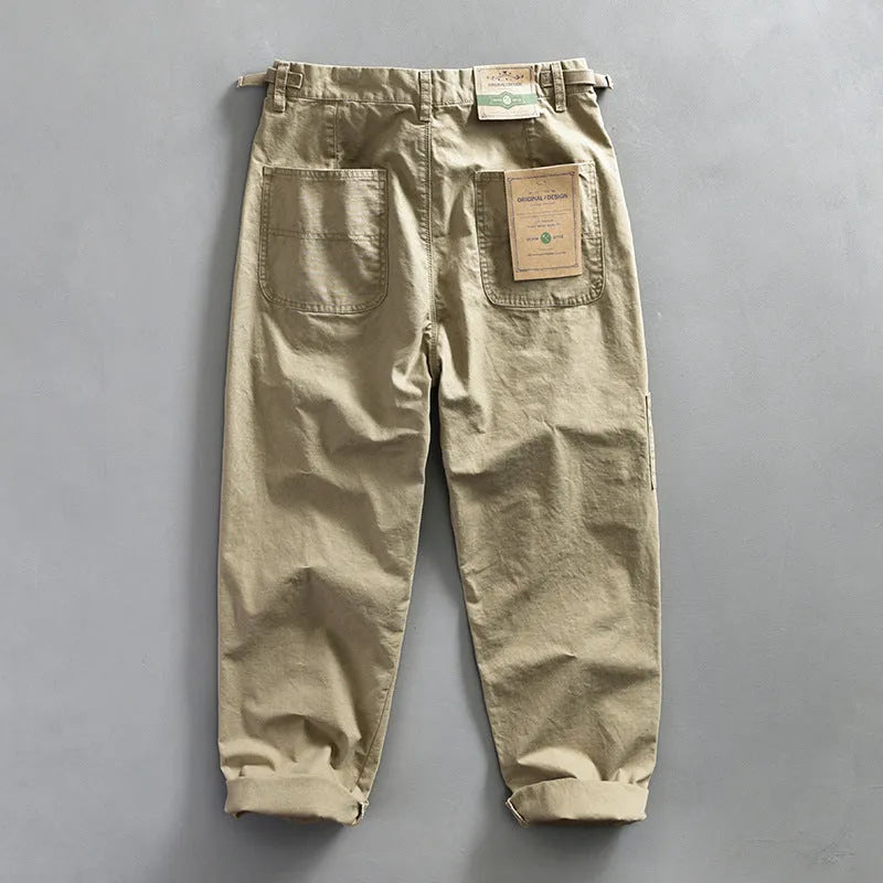 Men's straight-leg cotton trousers in apricot, shown laid flat to display the mid-waist and classic cut.