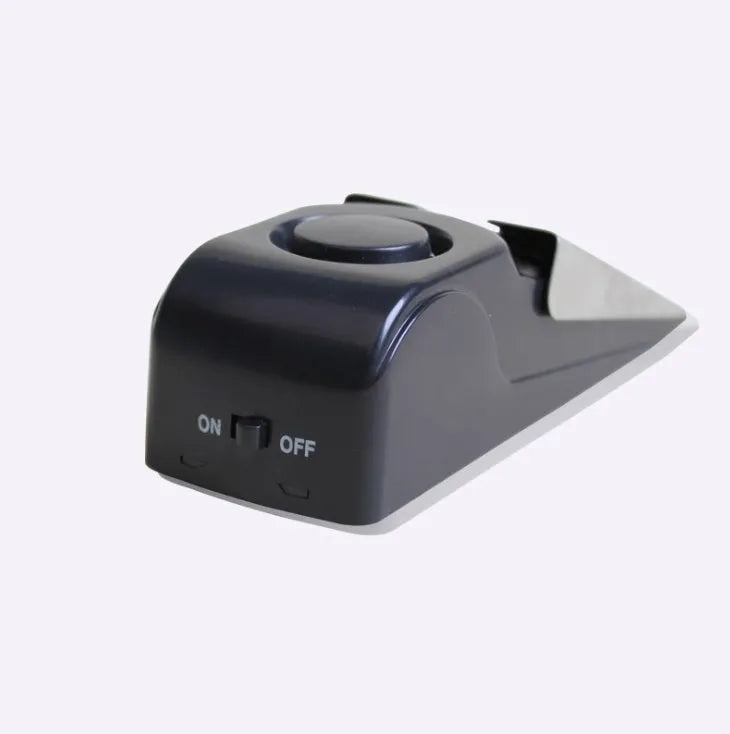 Black wedge-shaped door alarm with stainless steel cover and sensitivity controls