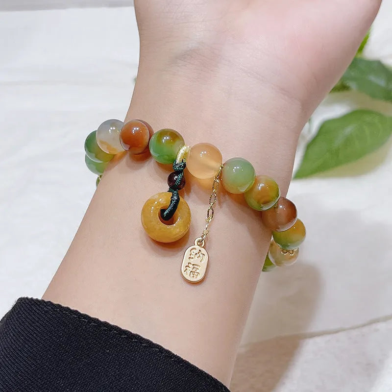 Yellow women's folk bracelet with peacock agate and topaz stones and a peace buckle clasp.