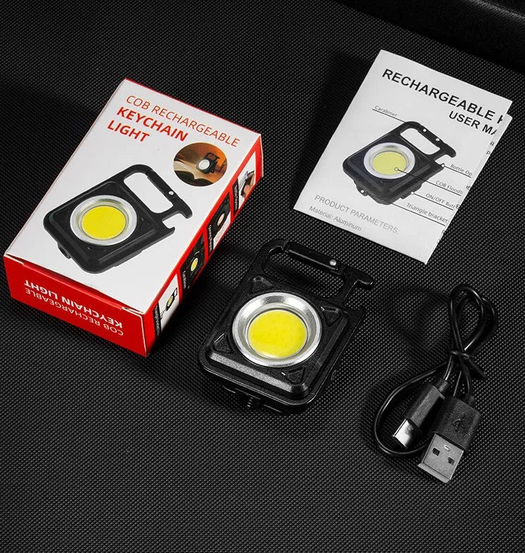 Black multifunctional portable LED torch with aluminium alloy body, magnet base, and control button on a wooden surface