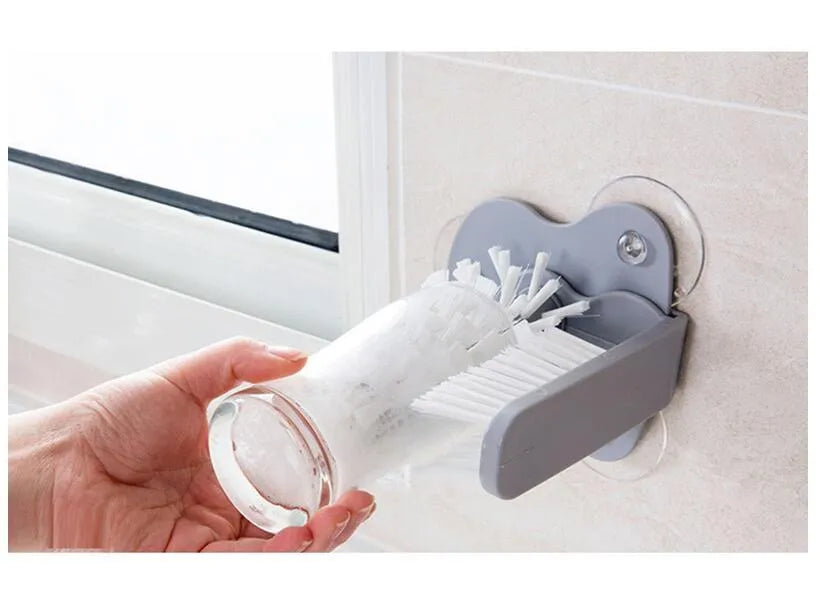 Grey double-headed cup cleaning brush with wall-mounted suction cups for kitchen use