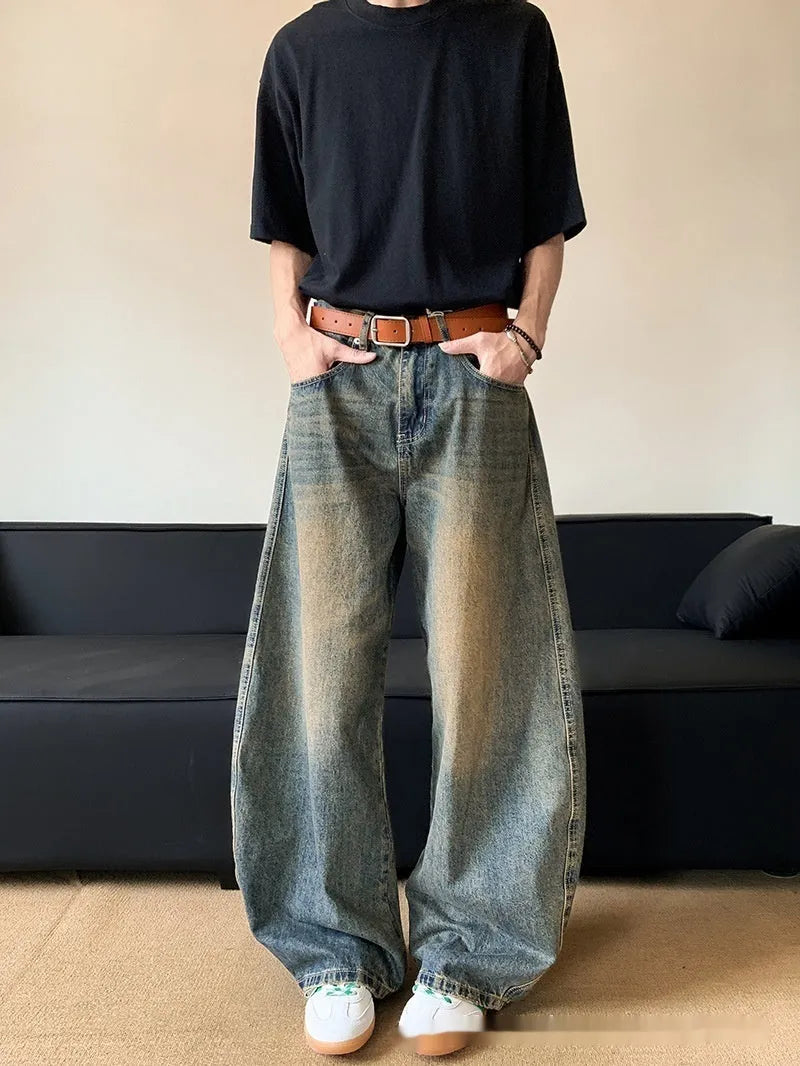 Men's retro blue distressed denim jeans with a slimming wide-leg fit and machete wash detail.
