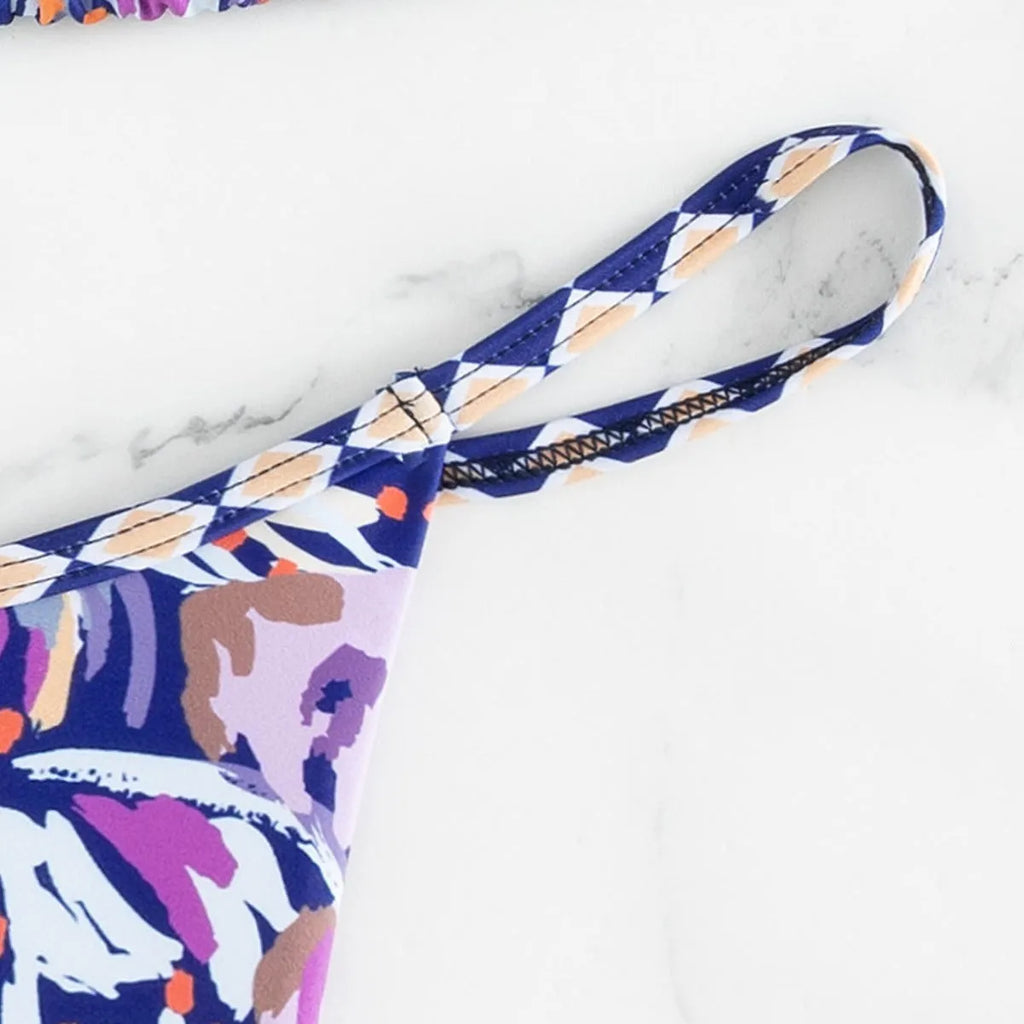 Women's floral print one-piece swimsuit with triangle bag design and split back in polyester.
