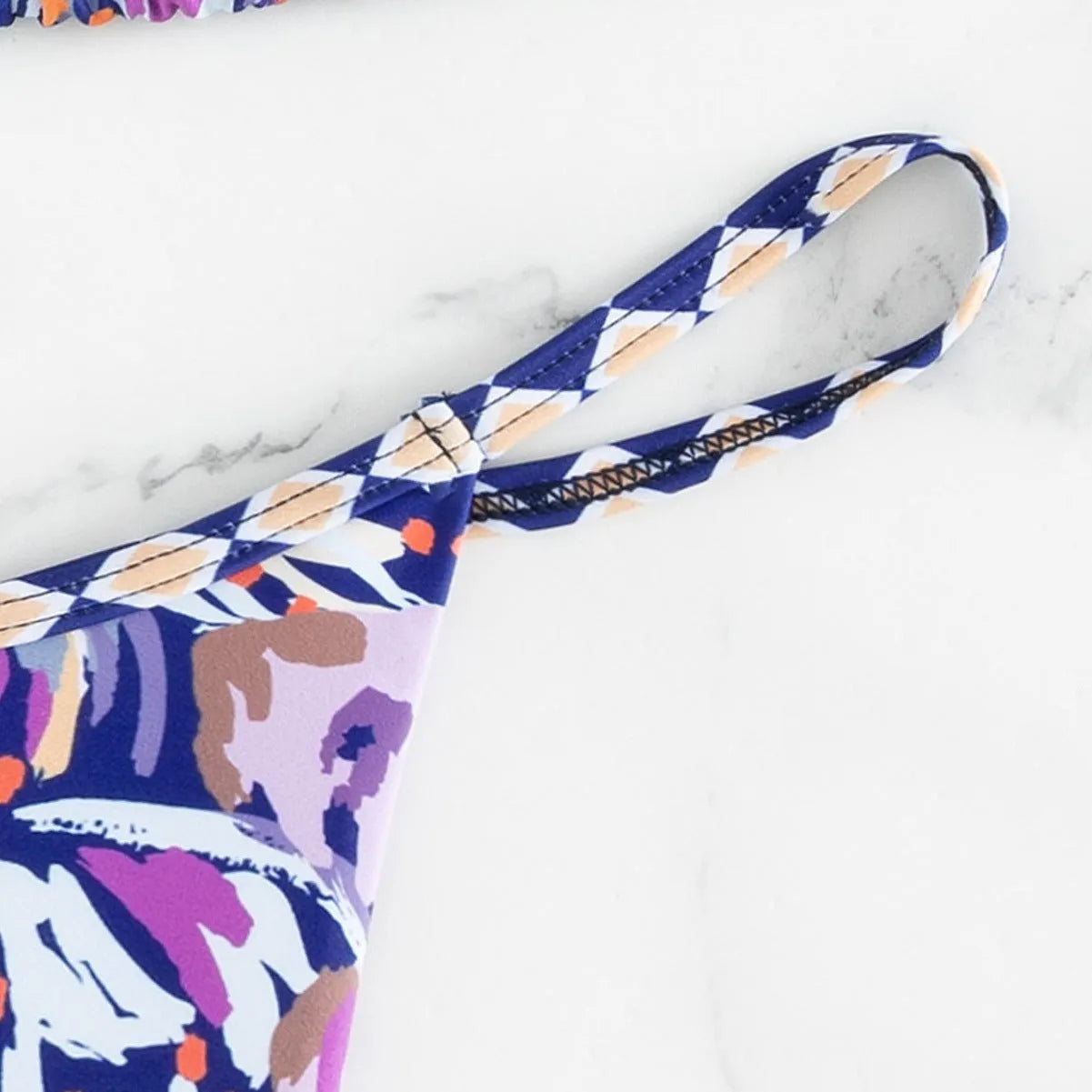Women's floral print one-piece swimsuit with triangle bag design and split back in polyester.