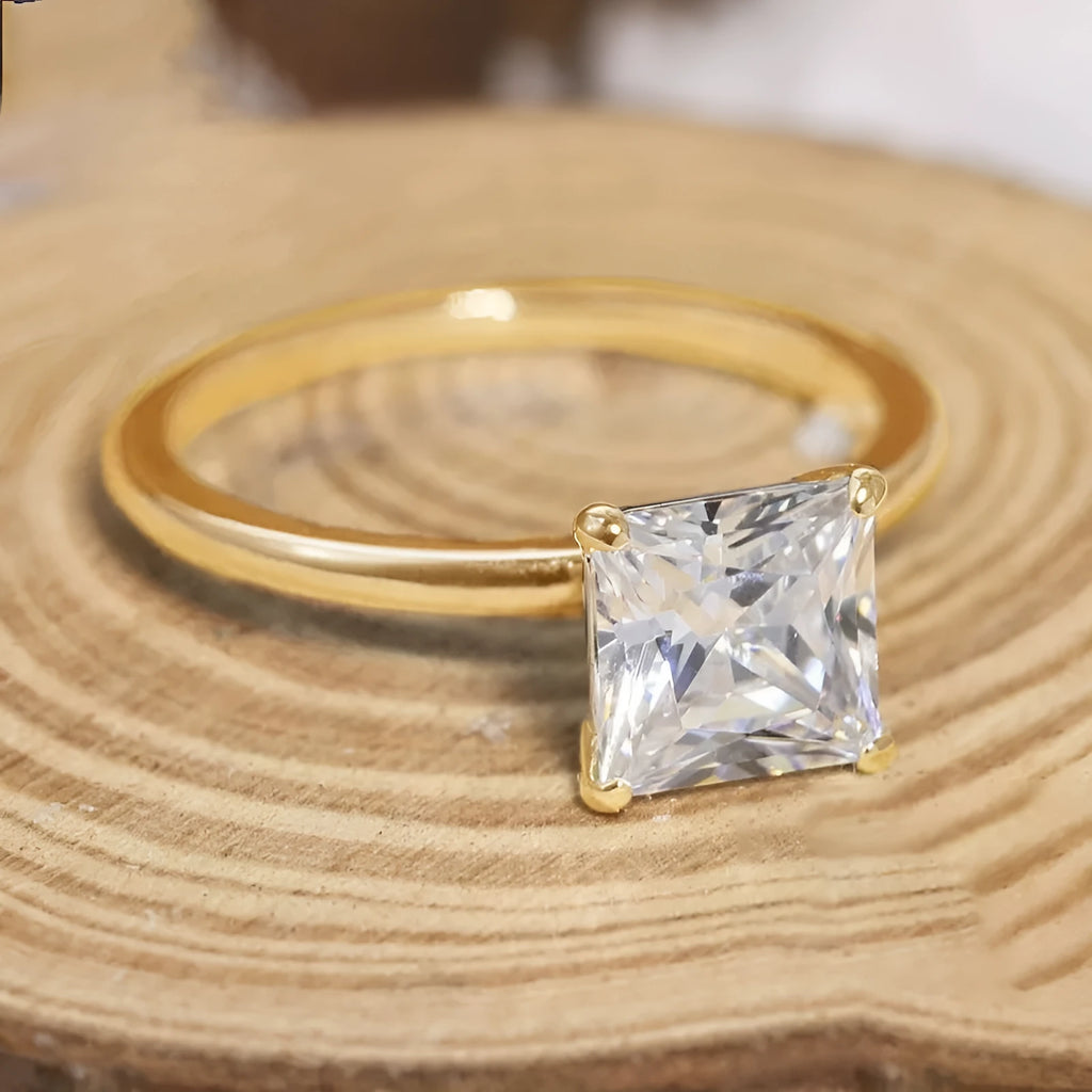 A polished geometric sterling silver ring for women on a grey background.